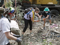 Locals are helping remove the rubble at a section of a five-storey apartment building in the Shevchenkivskyi district destroyed by the Russi...