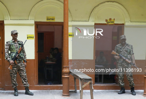 Indian paramilitary troopers are standing alert at a polling booth during the byelection in the Maniktala constituency in Kolkata, India, on...