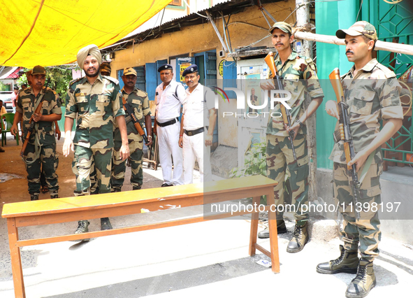 Indian paramilitary troopers are standing alert at a polling booth during the byelection in the Maniktala constituency in Kolkata, India, on...