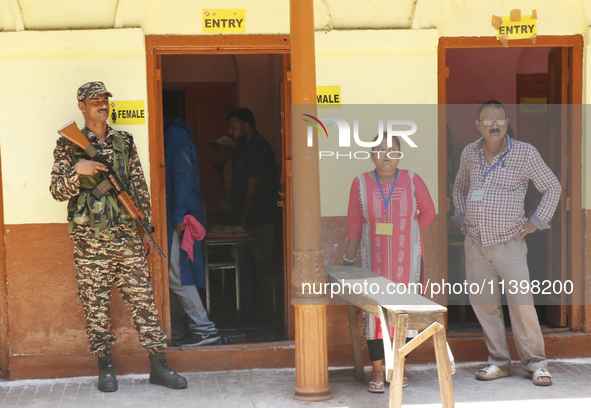 Indian paramilitary troopers are standing alert at a polling booth during the byelection in the Maniktala constituency in Kolkata, India, on...