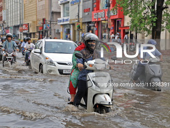 Commuters are wading through a waterlogged road during the monsoon rain in Jaipur, Rajasthan, India, on July 10, 2024. (