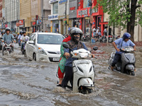 Commuters are wading through a waterlogged road during the monsoon rain in Jaipur, Rajasthan, India, on July 10, 2024. (