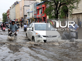 Commuters are wading through a waterlogged road during the monsoon rain in Jaipur, Rajasthan, India, on July 10, 2024. (