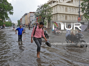 Commuters are wading through a waterlogged road during the monsoon rain in Jaipur, Rajasthan, India, on July 10, 2024. (