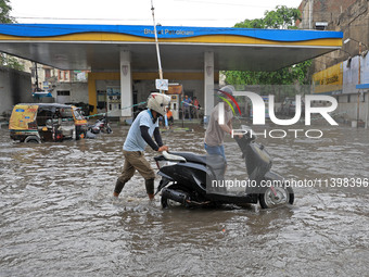 Commuters are wading through a waterlogged road during the monsoon rain in Jaipur, Rajasthan, India, on July 10, 2024. (