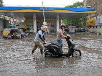 Commuters are wading through a waterlogged road during the monsoon rain in Jaipur, Rajasthan, India, on July 10, 2024. (