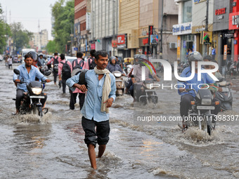 Commuters are wading through a waterlogged road during the monsoon rain in Jaipur, Rajasthan, India, on July 10, 2024. (