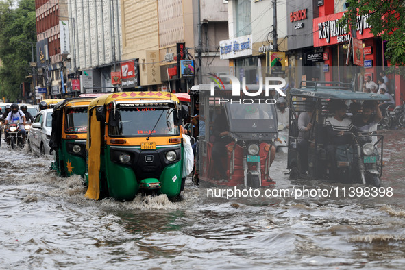 Commuters are wading through a waterlogged road during the monsoon rain in Jaipur, Rajasthan, India, on July 10, 2024. 