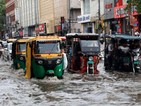 Commuters are wading through a waterlogged road during the monsoon rain in Jaipur, Rajasthan, India, on July 10, 2024. (