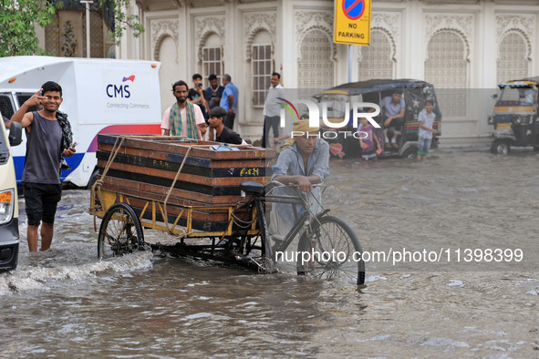 Commuters are wading through a waterlogged road during the monsoon rain in Jaipur, Rajasthan, India, on July 10, 2024. 