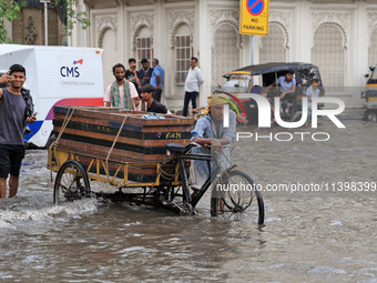 Commuters are wading through a waterlogged road during the monsoon rain in Jaipur, Rajasthan, India, on July 10, 2024. (