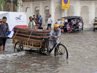 Commuters are wading through a waterlogged road during the monsoon rain in Jaipur, Rajasthan, India, on July 10, 2024. (