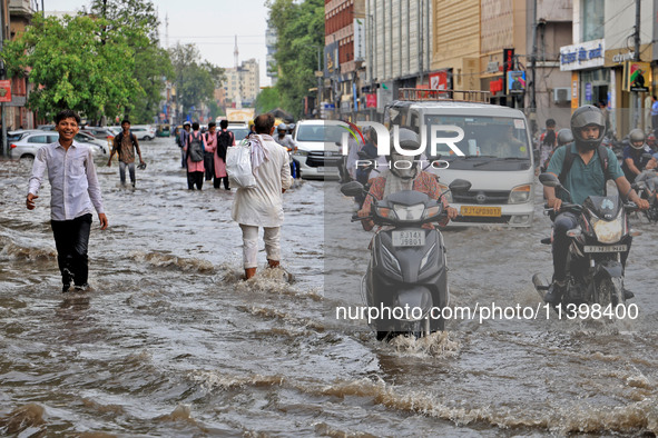 Commuters are wading through a waterlogged road during the monsoon rain in Jaipur, Rajasthan, India, on July 10, 2024. 