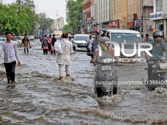 Commuters are wading through a waterlogged road during the monsoon rain in Jaipur, Rajasthan, India, on July 10, 2024. (