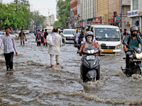 Commuters are wading through a waterlogged road during the monsoon rain in Jaipur, Rajasthan, India, on July 10, 2024. (