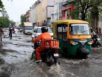 Commuters are wading through a waterlogged road during the monsoon rain in Jaipur, Rajasthan, India, on July 10, 2024. (