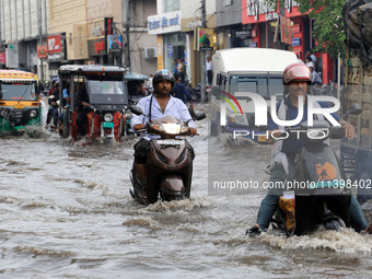 Commuters are wading through a waterlogged road during the monsoon rain in Jaipur, Rajasthan, India, on July 10, 2024. (