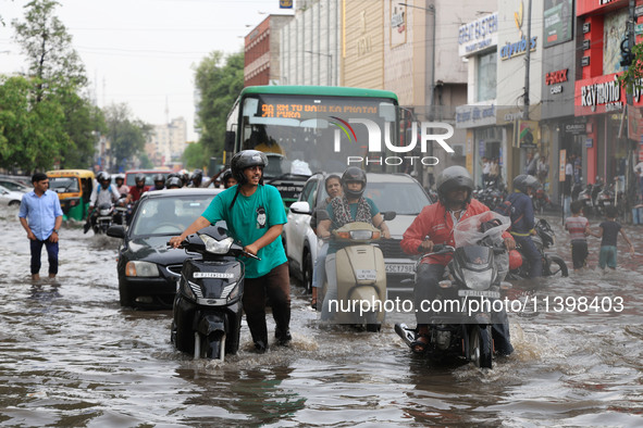 Commuters are wading through a waterlogged road during the monsoon rain in Jaipur, Rajasthan, India, on July 10, 2024. 