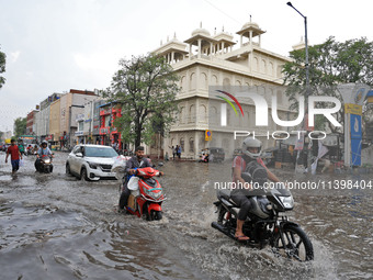 Commuters are wading through a waterlogged road during the monsoon rain in Jaipur, Rajasthan, India, on July 10, 2024. (