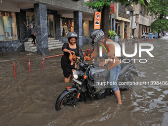 Commuters are wading through a waterlogged road during the monsoon rain in Jaipur, Rajasthan, India, on July 10, 2024. (