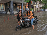 Commuters are wading through a waterlogged road during the monsoon rain in Jaipur, Rajasthan, India, on July 10, 2024. (