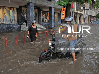 Commuters are wading through a waterlogged road during the monsoon rain in Jaipur, Rajasthan, India, on July 10, 2024. (