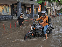 Commuters are wading through a waterlogged road during the monsoon rain in Jaipur, Rajasthan, India, on July 10, 2024. (