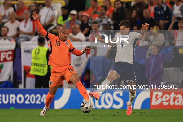 Donyell Malen (Netherlands) is battling with John Stones (England) during the Semi Final of the UEFA European Championship between England a...