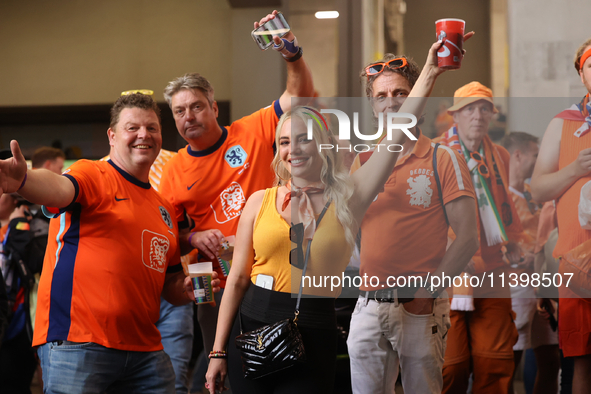 Fans are hiding from the rain before the Semi Final of the UEFA European Championship between England and Netherlands at the BVB Stadion in...