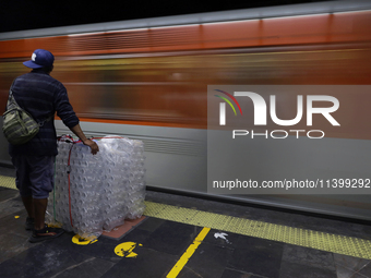 A person is waiting with packaging to board a metro train in Mexico City, Mexico, on june 10, 2024. (