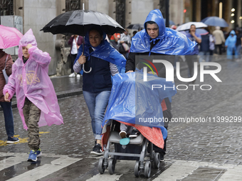 People are covering themselves from the rain with raincoats on the streets of Mexico City. (