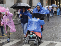 People are covering themselves from the rain with raincoats on the streets of Mexico City. (