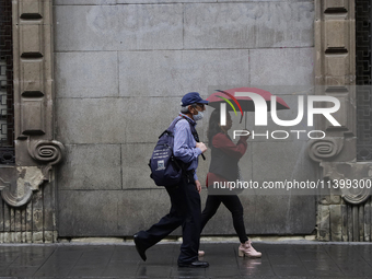 People are walking in the rain on the streets of Mexico City. (