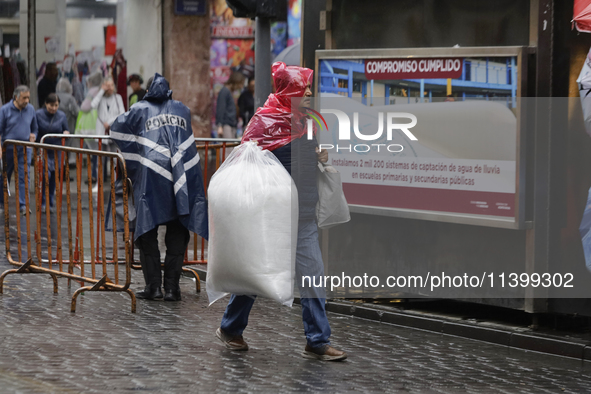 A person is walking in the rain on the streets of Mexico City, Mexico, on june 10, 2024. 