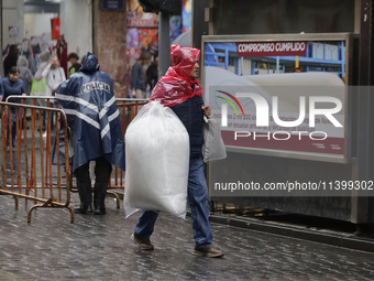 A person is walking in the rain on the streets of Mexico City, Mexico, on june 10, 2024. (