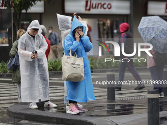 People are covering themselves from the rain with raincoats on the streets of Mexico City. (