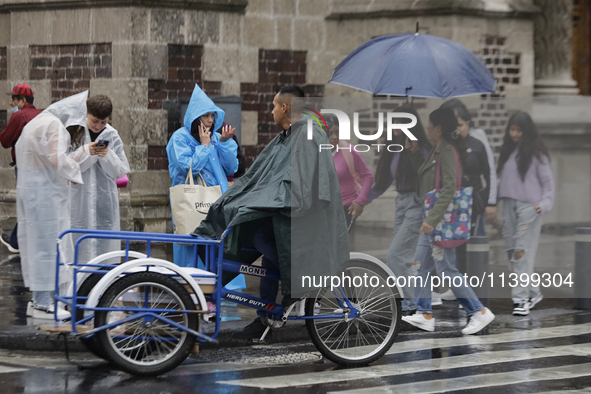 People are walking in the rain on the streets of Mexico City. 