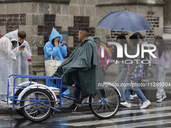 People are walking in the rain on the streets of Mexico City. (