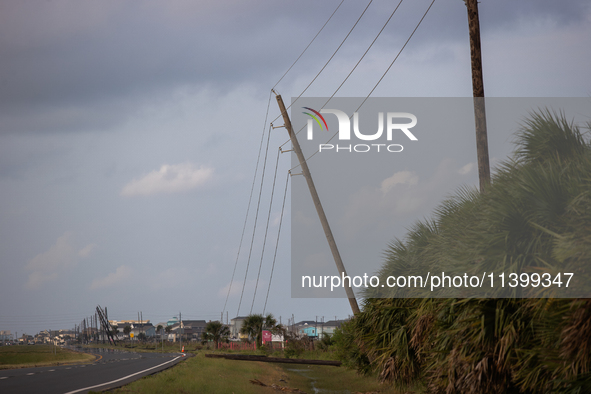 A row of power line support poles is falling along FM-3005 in Galveston, Texas, on July 10, 2024, in the wake of Hurricane Beryl. 1.1 millio...