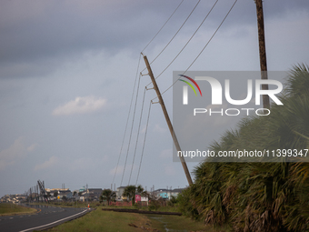 A row of power line support poles is falling along FM-3005 in Galveston, Texas, on July 10, 2024, in the wake of Hurricane Beryl. 1.1 millio...