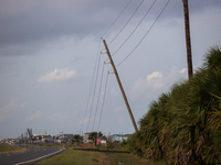 A row of power line support poles is falling along FM-3005 in Galveston, Texas, on July 10, 2024, in the wake of Hurricane Beryl. 1.1 millio...