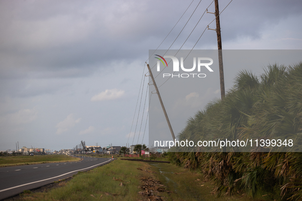 A row of power line support poles is falling along FM-3005 in Galveston, Texas, on July 10, 2024, in the wake of Hurricane Beryl. 1.1 millio...