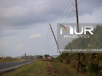 A row of power line support poles is falling along FM-3005 in Galveston, Texas, on July 10, 2024, in the wake of Hurricane Beryl. 1.1 millio...