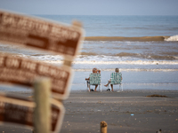 A couple is sitting on Pirates Beach in Galveston, Texas, on July 10, 2024. (