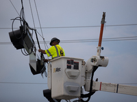 An electrical lineman is working on one of the many broken traffic lights in the Galveston area on July 10, 2024. (