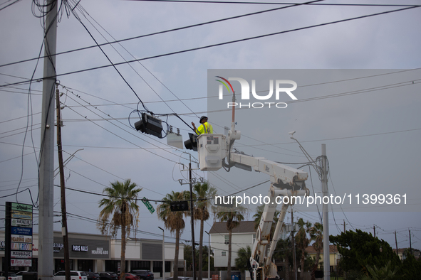 An electrical lineman is working on one of the many broken traffic lights in the Galveston area on July 10, 2024. 