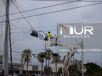 An electrical lineman is working on one of the many broken traffic lights in the Galveston area on July 10, 2024. (