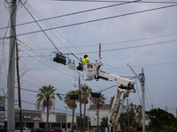 An electrical lineman is working on one of the many broken traffic lights in the Galveston area on July 10, 2024. (