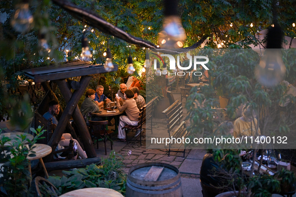 People are staying at an outdoor cafe in a courtyard in Lviv, Ukraine, on July 5, 2024. NO USE RUSSIA. NO USE BELARUS. 