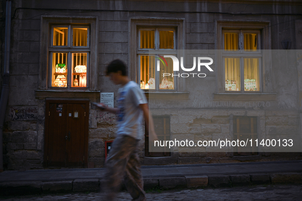 Lamps made of stained glass are on display in the windows of architect Pavlovsky's studio during a power outage at night in Lviv, Ukraine, o...